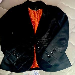 A black blazer size in us 2, made in Cambodia, brand H&M and in good condition.